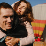 Farebný teplovzdušný balón letiaci vysoko na oblohe počas vyhliadkového letu nad krajinou.