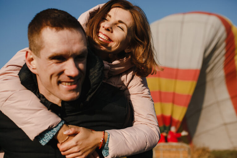 Farebný teplovzdušný balón letiaci vysoko na oblohe počas vyhliadkového letu nad krajinou.